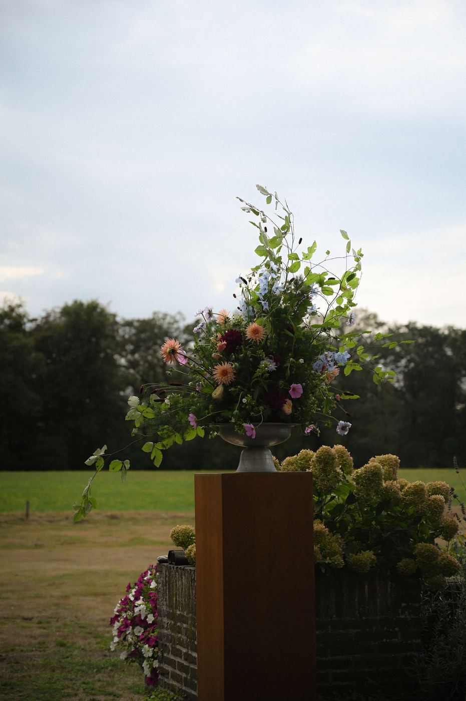 Bloemsculptuur op een sokkel aan de rand van een weiland