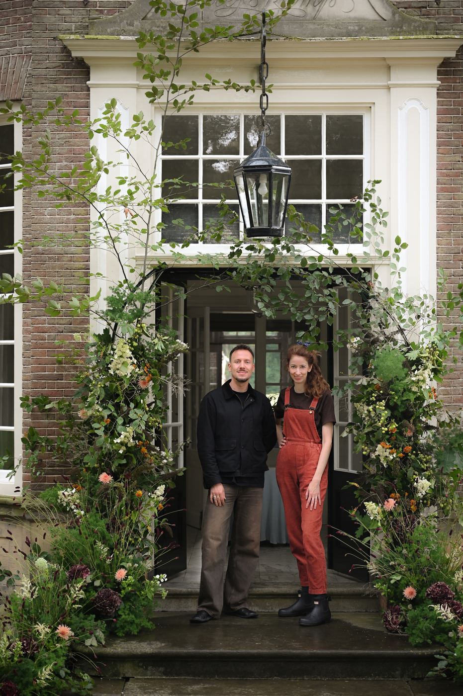 Riekje van Doorn en Michiel Bosman in de deuropening onder een bloeminstallatie